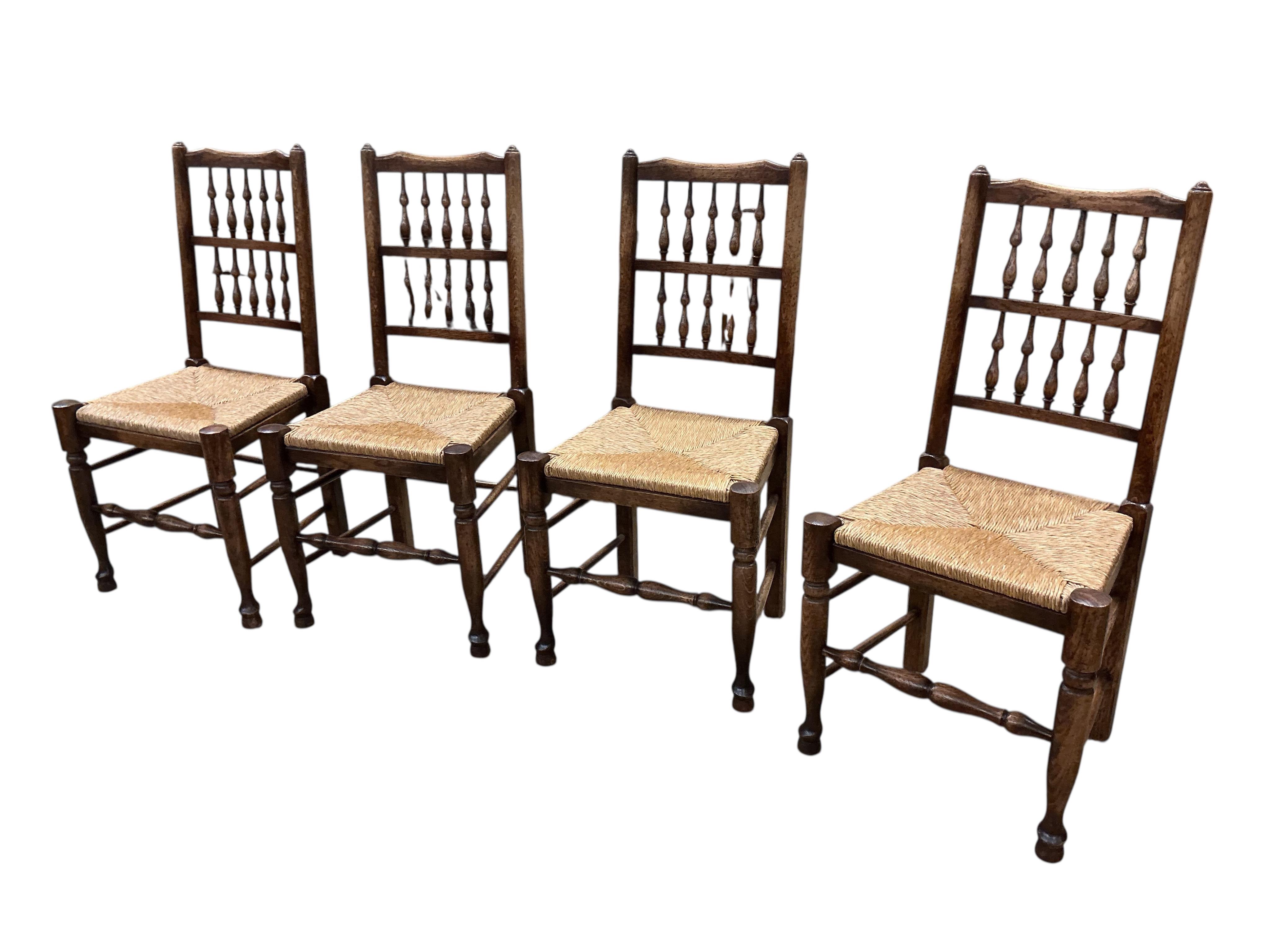 A set of ten Lancashire style ash and beech rush seat spindle back dining chairs, two with arms